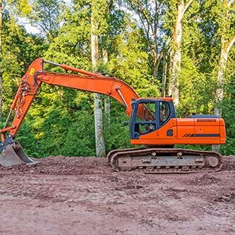 Orange crawler excavator standing in the woods